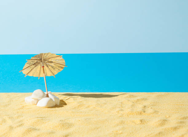istock Sun umbrella in the sand on blue background. Creative beach vacation concept. Minimal summer idea. 1328405306