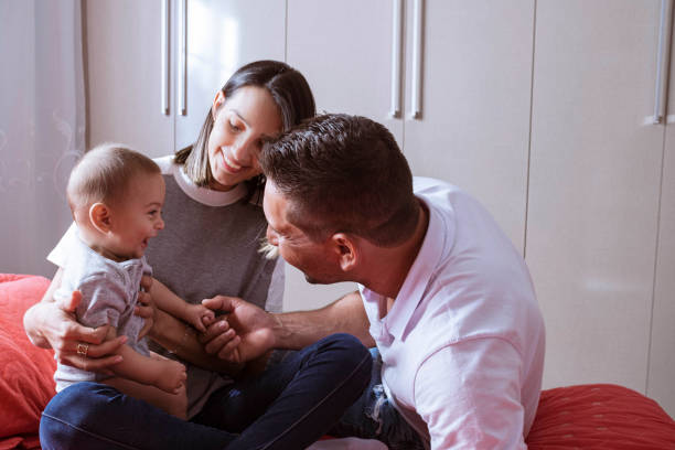 istock Parents playing with newborn child in bed 1328406500