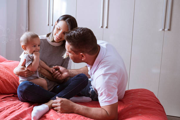 istock Parents playing with newborn child in bed 1328406532