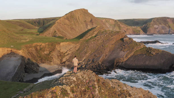 istock Hiker relaxes on rugged coastal mountain peak 1328409649