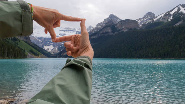 malerische ansicht der hände der frau, die lake louise konzeptionell einfängt - lake tranquil scene landscape zen like stock-fotos und bilder