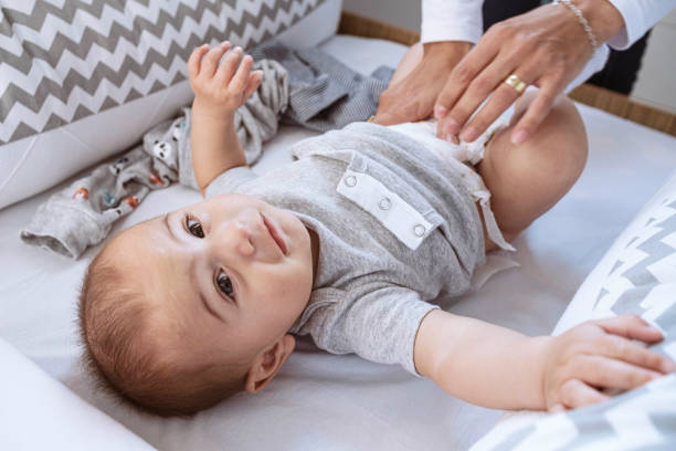 istock Newborn looking at camera when mother puts on new diaper 1328410920