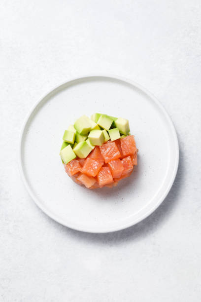 istock Salmon avocado tartare on white stone table background. 1328411556