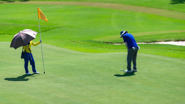 istock Caddie working on the green on the golf course. 1328414752