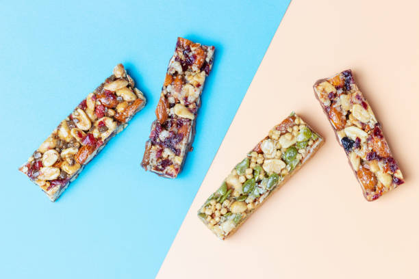 istock Four protein bars with cereals isolated on brown and blue background. 1328417558