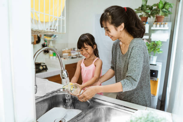 istock mother and daughter washing dishes 1328418112