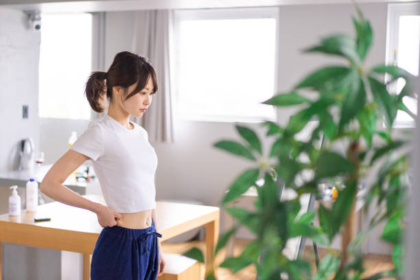 mujer joven a dieta con sonrisa - dieting mirror healthy lifestyle women fotografías e imágenes de stock