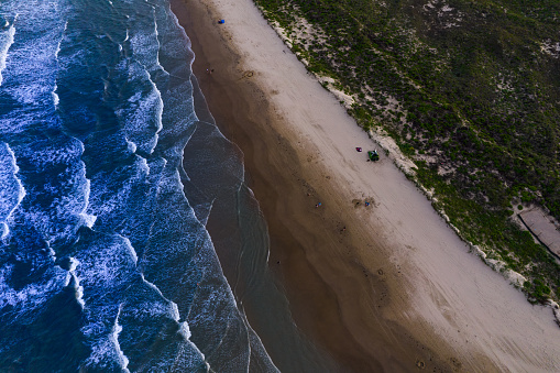 Waves , Sand , and Dunes looking down from high above Barrier island along South Texas Coastline , aerial drone view from high above South Padre Island , Texas , USA