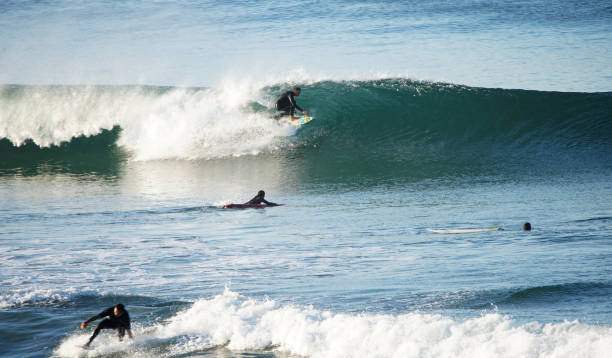 ハンティントンビーチで秋のうねりを楽しむサーファー - huntington beach ストックフォトと画像