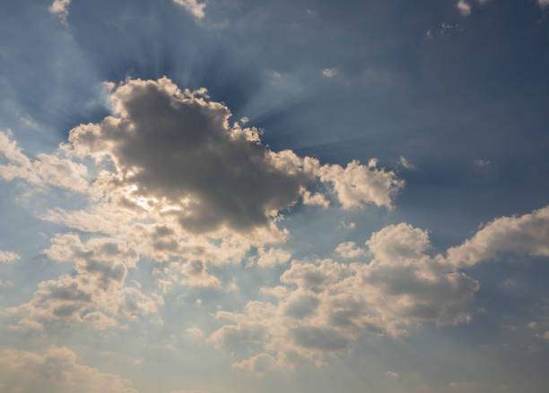 istock sunshine through clouds. dramatic clouds sky. high in the heaven. heavenly sky. sunrays sunbeams shine through dramatic clouds above the ocean. reflection of golden light shines on the water surface. 1328432440