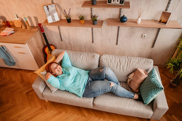 istock Woman relaxing on sofa with hands behind head 1328435089