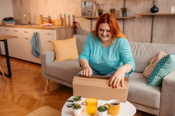 istock Woman customer opening cardboard box parcel 1328436144