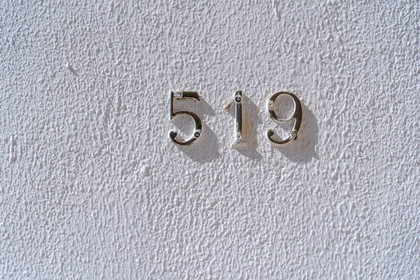 istock Metal house number 519 on a white stucco wall background 1328441188