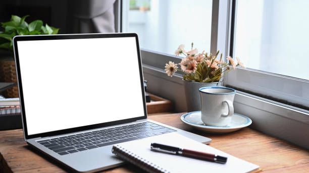istock Computer laptop, notebook and coffee cup on wooden tablet in coffee shop. 1328442567