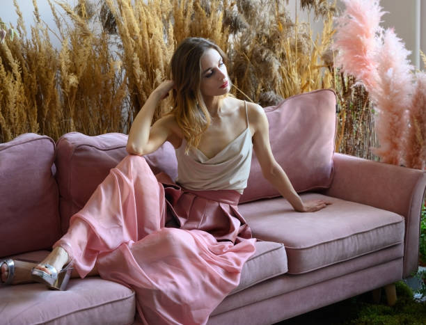 istock Nice woman sitting on a sofa in a room in tall grass 1328443454