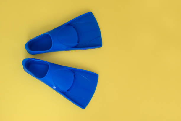 istock Blue flippers on a yellow background. Flat lay. Copy space 1328444730