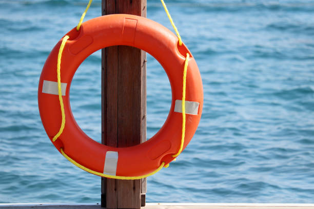 istock Orange lifebuoy on a beach 1328449591