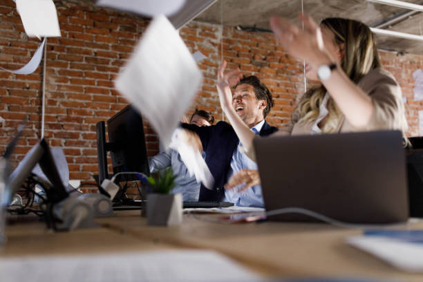 istock Cheerful entrepreneurs throwing reports while celebrating success in the office. 1328450389