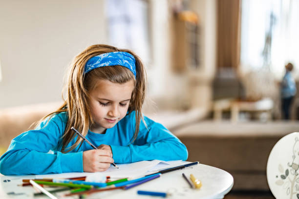 istock Little boy enjoying while drawing on a paper at home. 1328451501