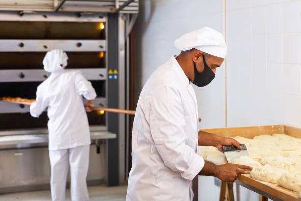 istock Bakery owner preparing portioned pieces of dough for baking 1328451744