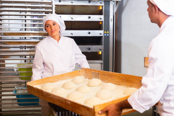 istock Female baker preparing shaped raw dough for proofing 1328451756