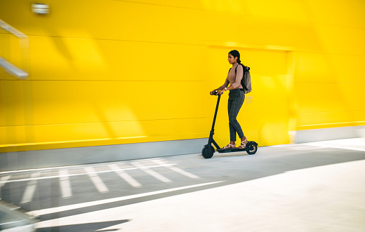 Young Businesswoman Riding a Electric Scooter