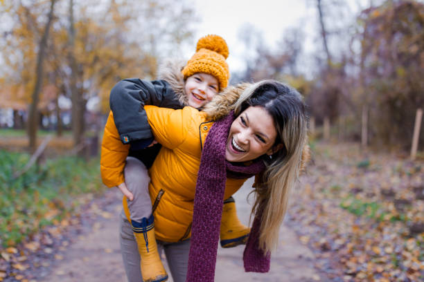 istock Cheerful single mother and her small son having fun while piggybacking in nature. 1328453400