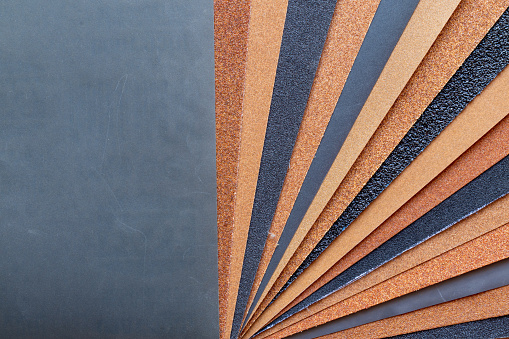 The background of the sandpaper surface, where the grains of sand on the sandpaper can be seen, and the difference in colors on the sandpaper indicate the fineness of the grains of sand.