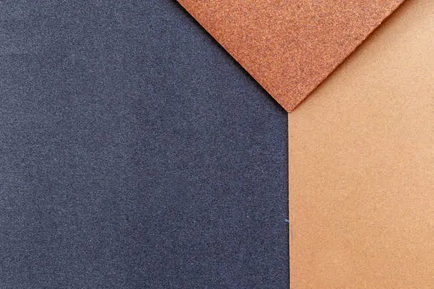 Photo of The background of the sandpaper surface, where the grains of sand on the sandpaper can be seen, and the difference in colors on the sandpaper indicate the fineness of the grains of sand.