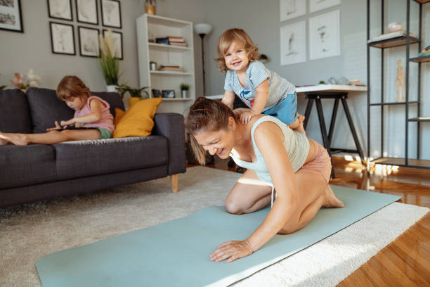 istock Pregnant mother exercising while daughters distract her 1328455805