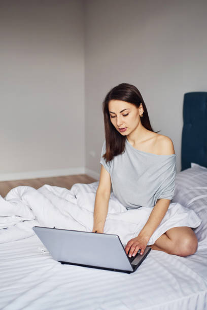istock Using laptop. Young woman resting and spending weekend at home alone at home 1328458454