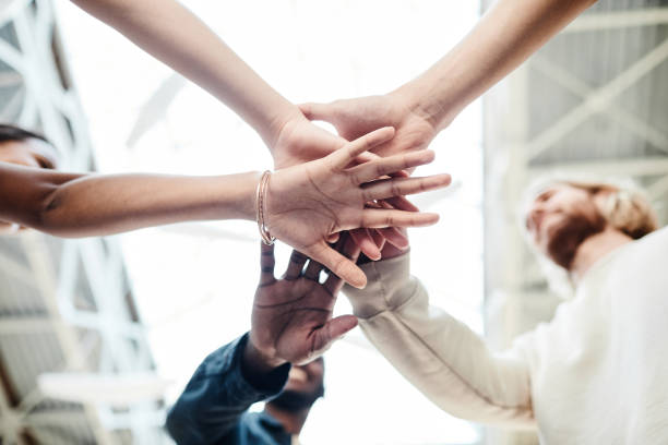 istock Diverse Group of Friends Stacking Hands Outdoors 1328460685