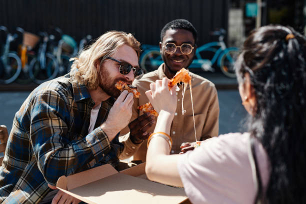 istock Young People Eating Pizza Outdoors 1328460725
