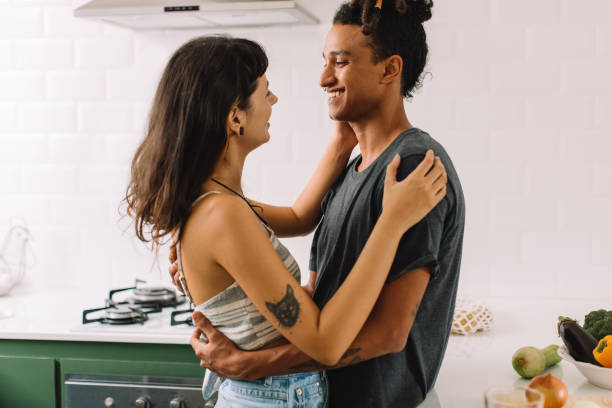 istock Affectionate young couple smiling at each other in the kitchen 1328462272