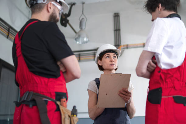 istock Group of workers with helmet indoors in factory, discussing issues. 1328462999