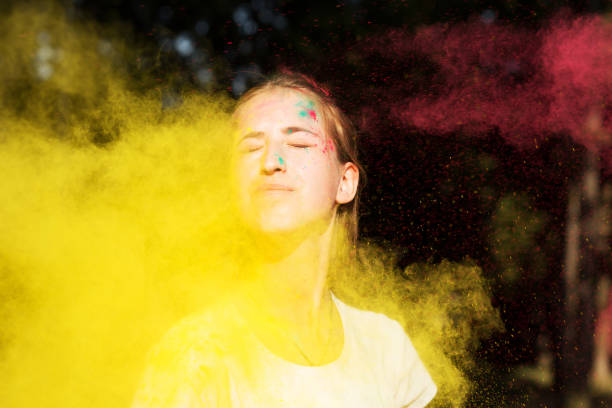 istock Adorable blonde woman in vibrant colors exploding around her at Holi celebration 1328463848
