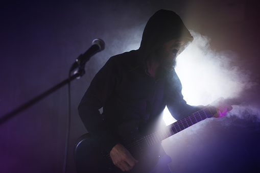 Heavy metal rock guitarist playing guitar in a live show with stage lights