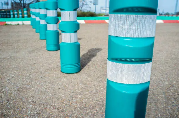 Green plastic bollards with reflective tape. Selective focus