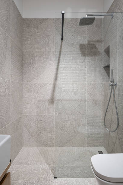 istock Spacious shower with glass wall in bathroom with patterned tiles 1328468148