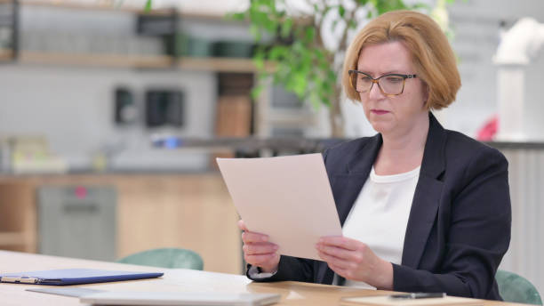 istock Senior Old Businesswoman Reading Documents at Work 1328471766