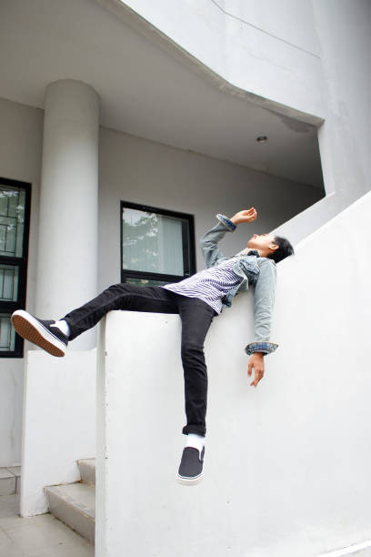 istock young adult man lying on a wall 1328472070