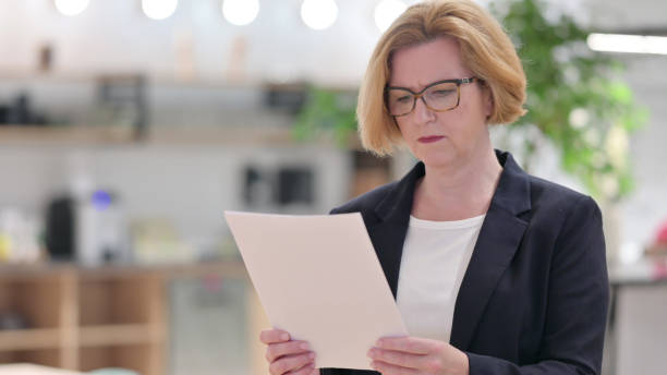 istock Portrait of Old Businesswoman Reading Documents 1328472964