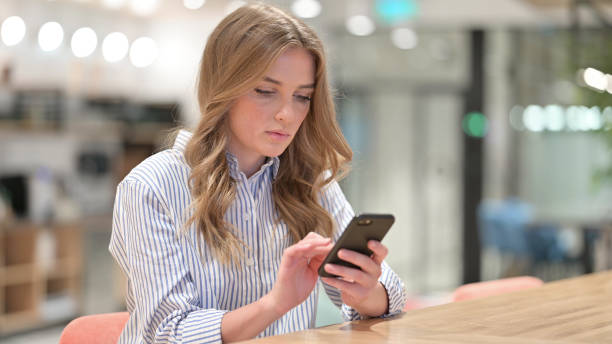 istock Serious Businesswoman using Smartphone in Office 1328473169