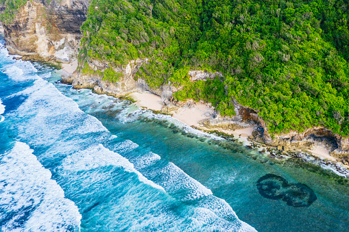 Bali rocky shores and clear transparent ocean on the south Bukit. View from above. Waves hitting cliffs.