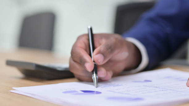 istock Paperwork by African Businessman, Financial Documents 1328474509