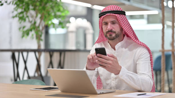 istock Professional Arab Businessman using Smartphone and Laptop 1328474694