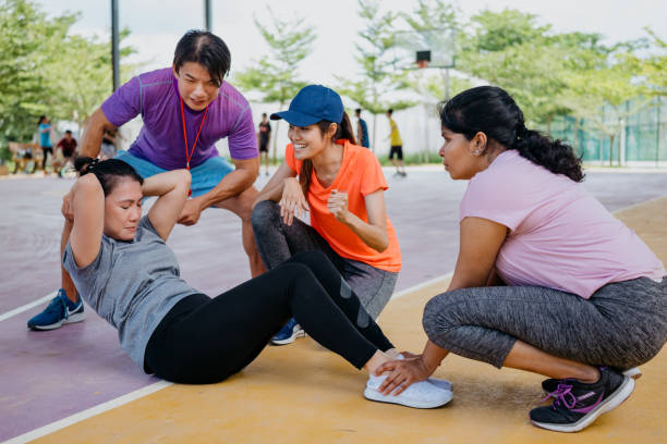 istock Asian woman doing sit-ups with friends 1328475069