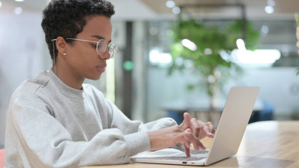 istock Young African Woman using Laptop in Office 1328475889