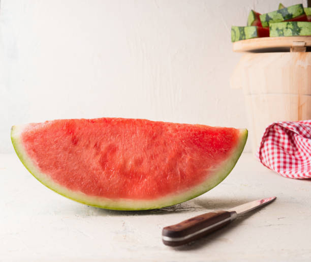 istock Piece of watermelon on white table with knife. 1328476168