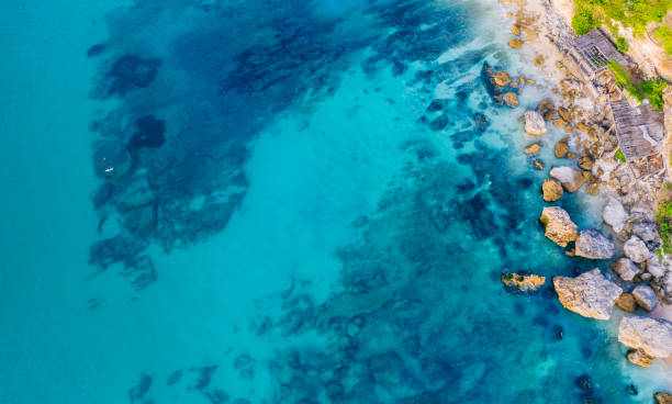 istock Blue ocean, rocky beach and cliffs. View from above. 1328476325